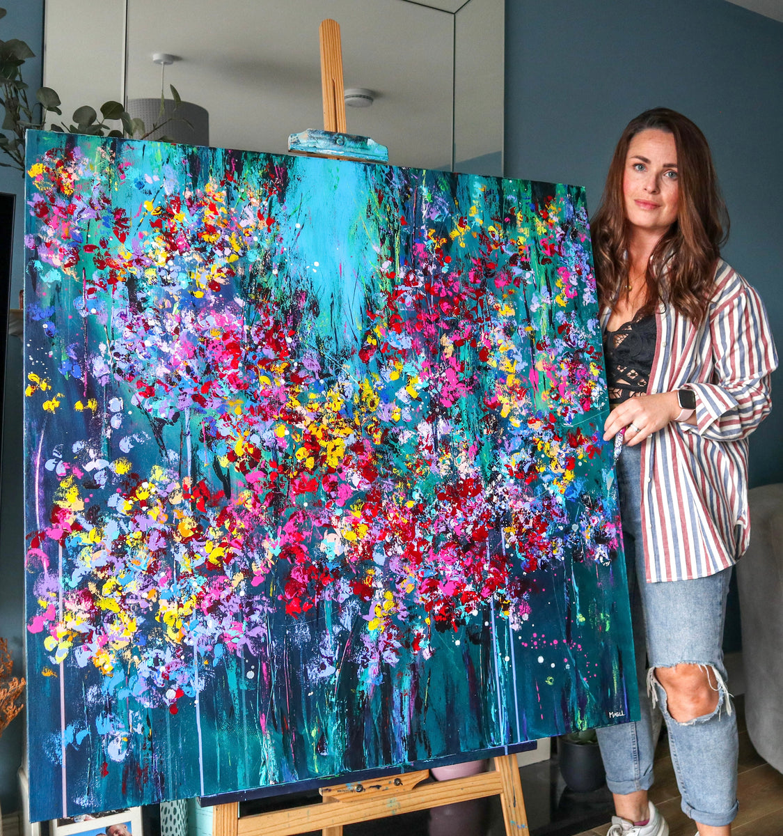 Northern Irish Artist Rachel Magill with vibrant abstract painting in living room 